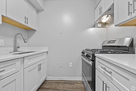 the kitchen of our studio apartment atrium with white cabinets and stainless steel appliances