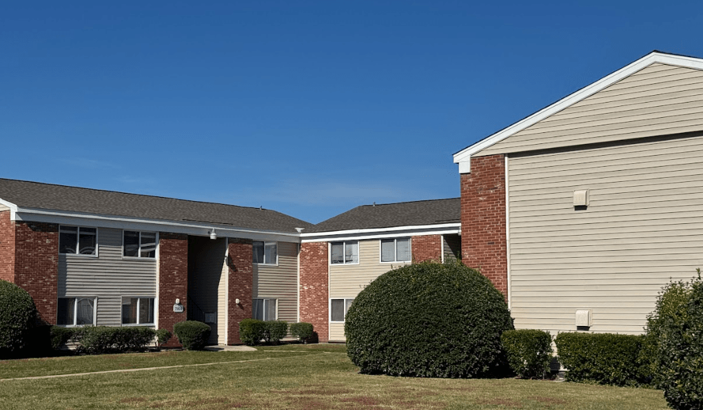 A row of houses with a green lawn in front.