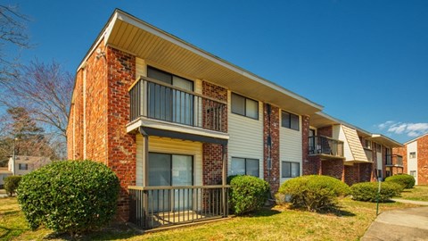 an apartment building with a balcony and a sidewalk