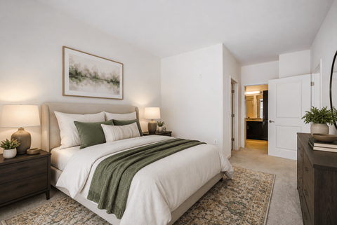 A bedroom with a large bed and a painting on the wall.