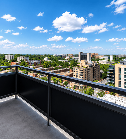 A balcony overlooks a cityscape with buildings and trees.