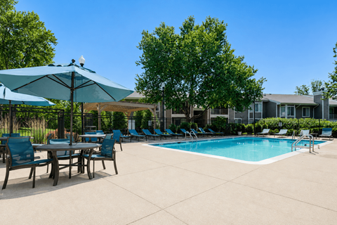 A pool area with chairs and umbrellas.