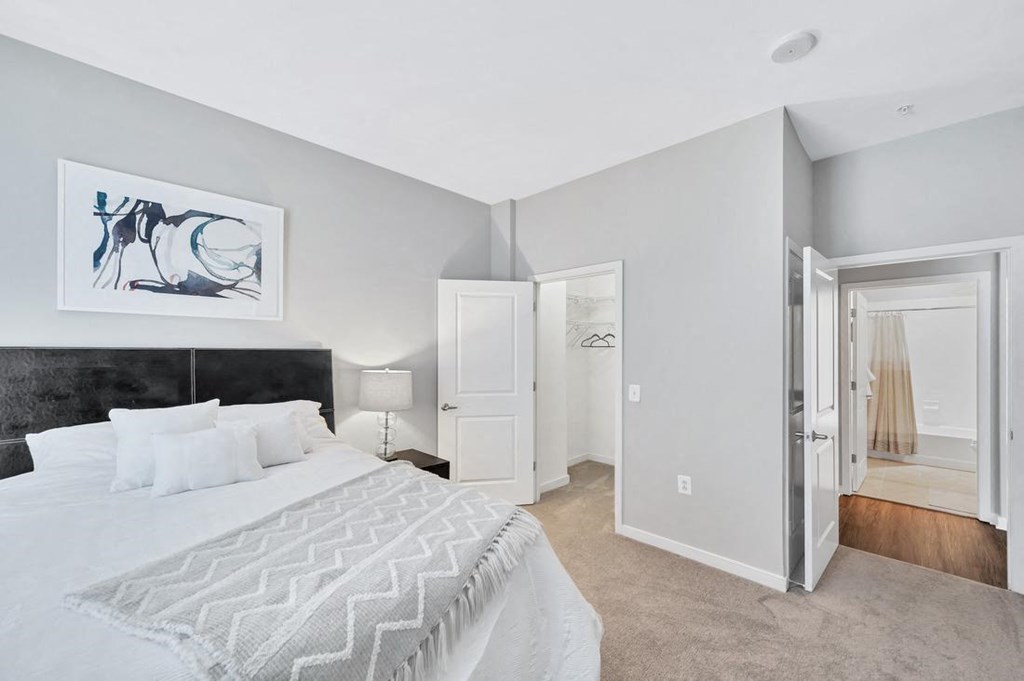 a bedroom with a large bed and a door to a bathroom