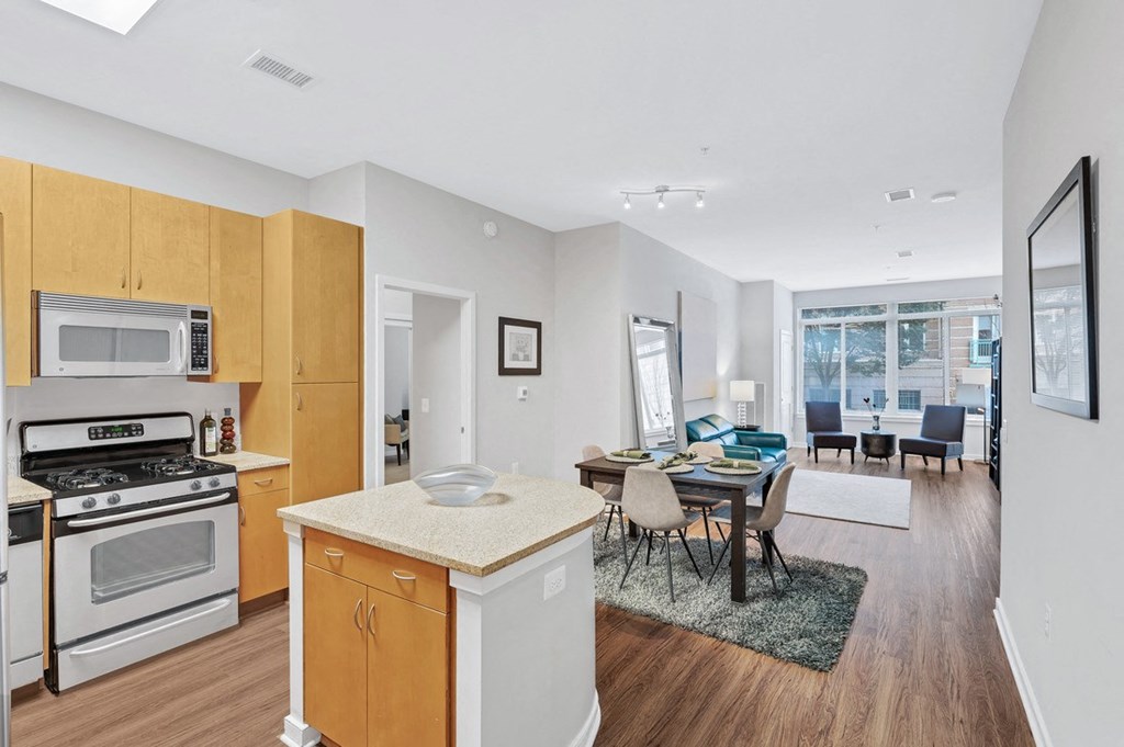 a kitchen and living room with a dining room in the background