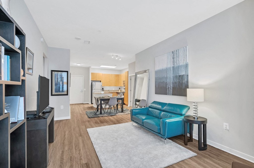 a living room with a blue couch and a dining room table