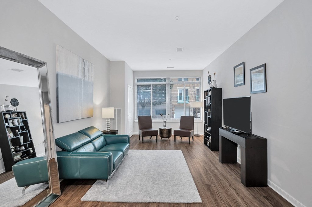 a living room with a green leather couch and a flat screen tv