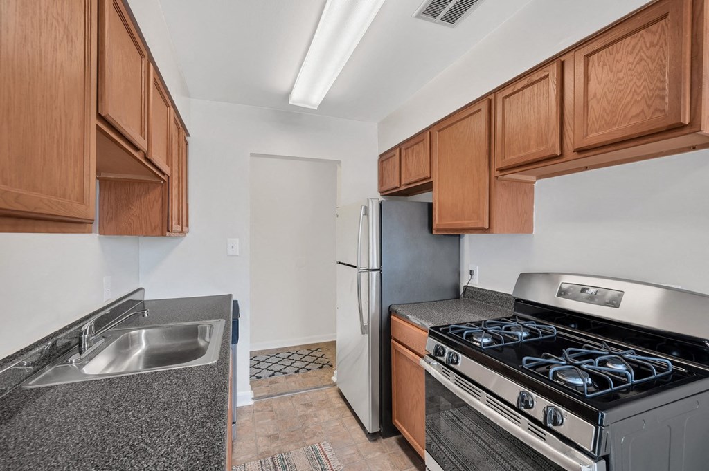 a kitchen with wood cabinets and stainless steel appliances
