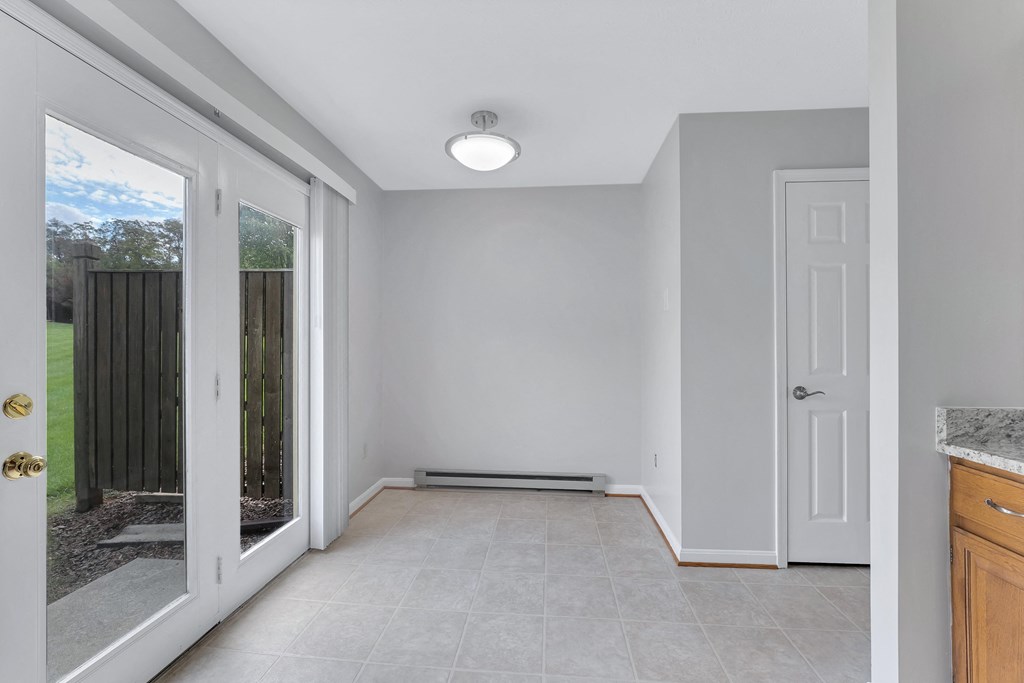 an empty room with a door to a yard and a window