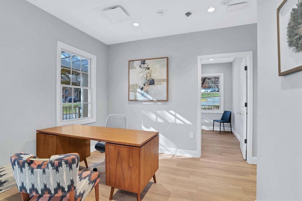 a home office with a wooden desk and chairs