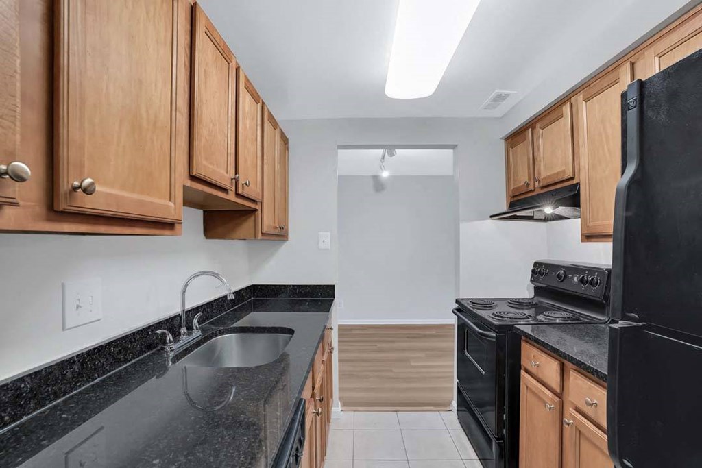 a kitchen with black appliances and wooden cabinets