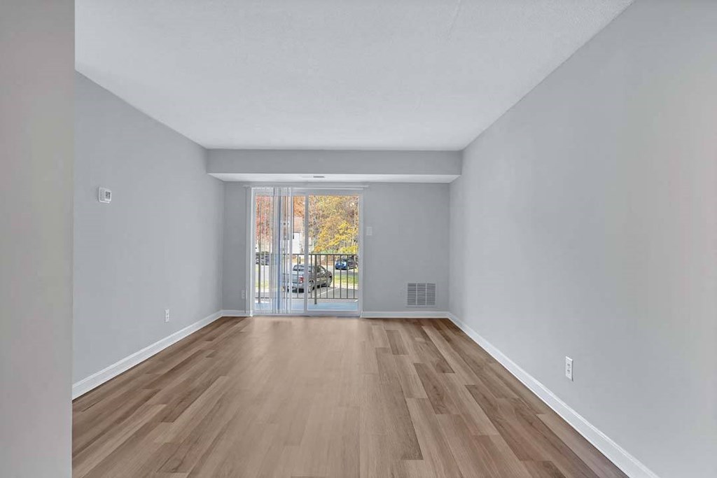 the living room is spacious and has a sliding glass door to the balcony