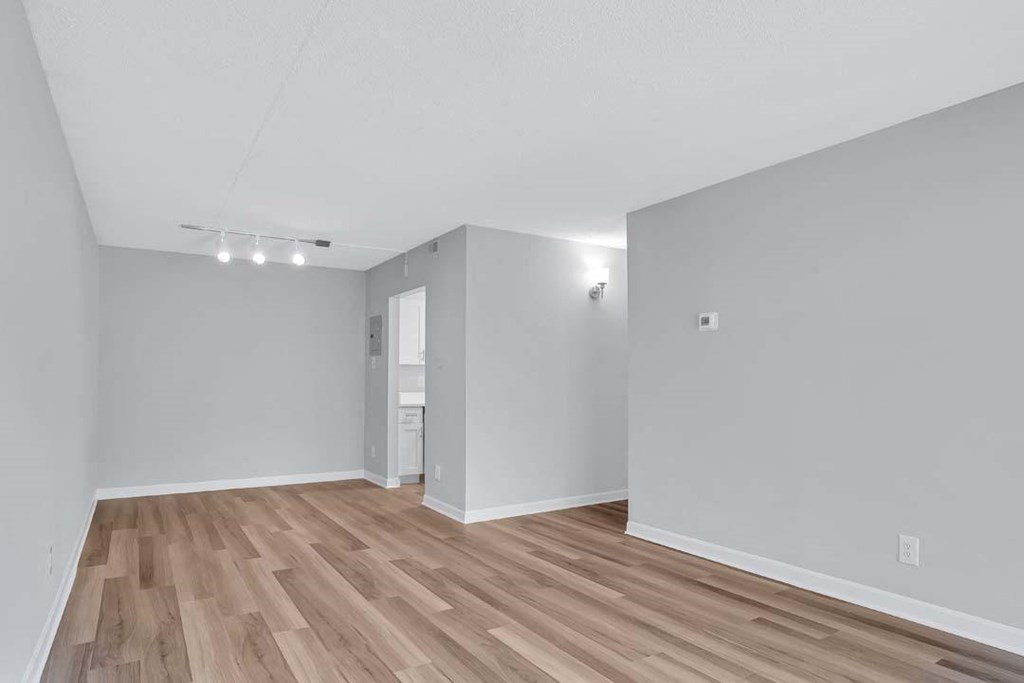 the living room and dining room of an empty house with wood floors