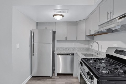a kitchen with white cabinets and a stainless steel refrigerator