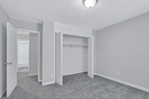 an empty bedroom with a closet and a mirrored closet door