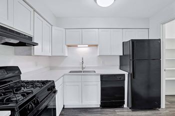 a kitchen with white cabinets and a black refrigerator