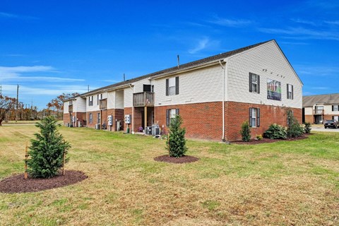 A large apartment complex with a grassy area in front.