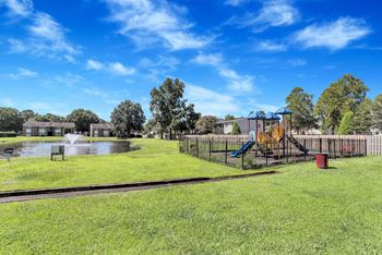 the park has a playground and a pond with a swing set