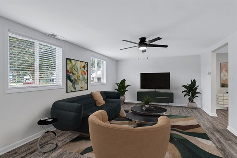 A living room with a sofa, chair, and television.