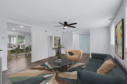 A living room with a green couch and a rug with a leaf pattern.