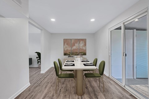 A dining room with a table set for six people.