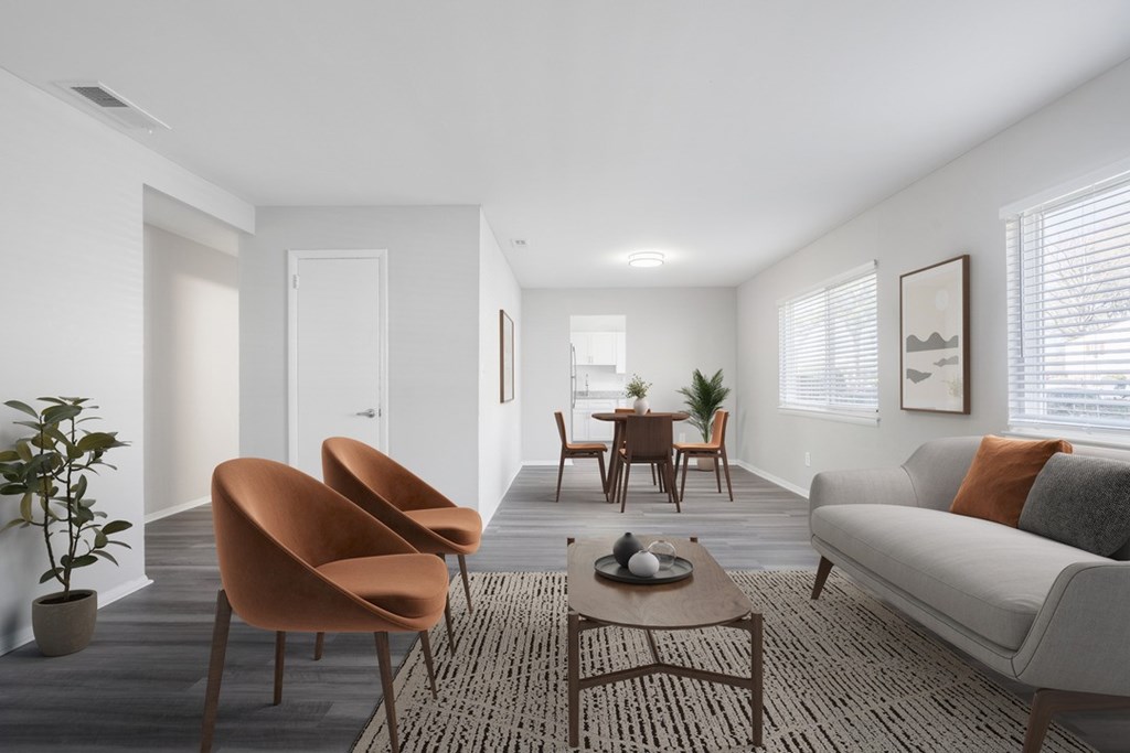 A living room with a grey couch, orange chairs, and a coffee table.