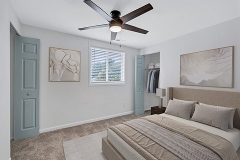 A bedroom with a large bed and a ceiling fan.