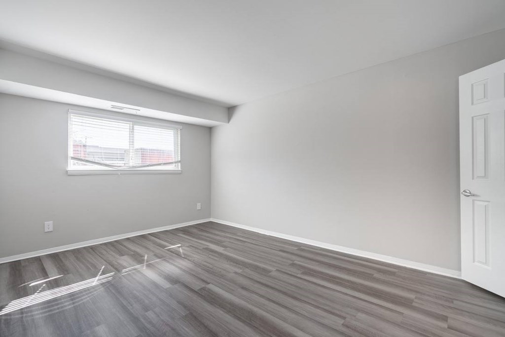 A room with a window and wooden flooring.