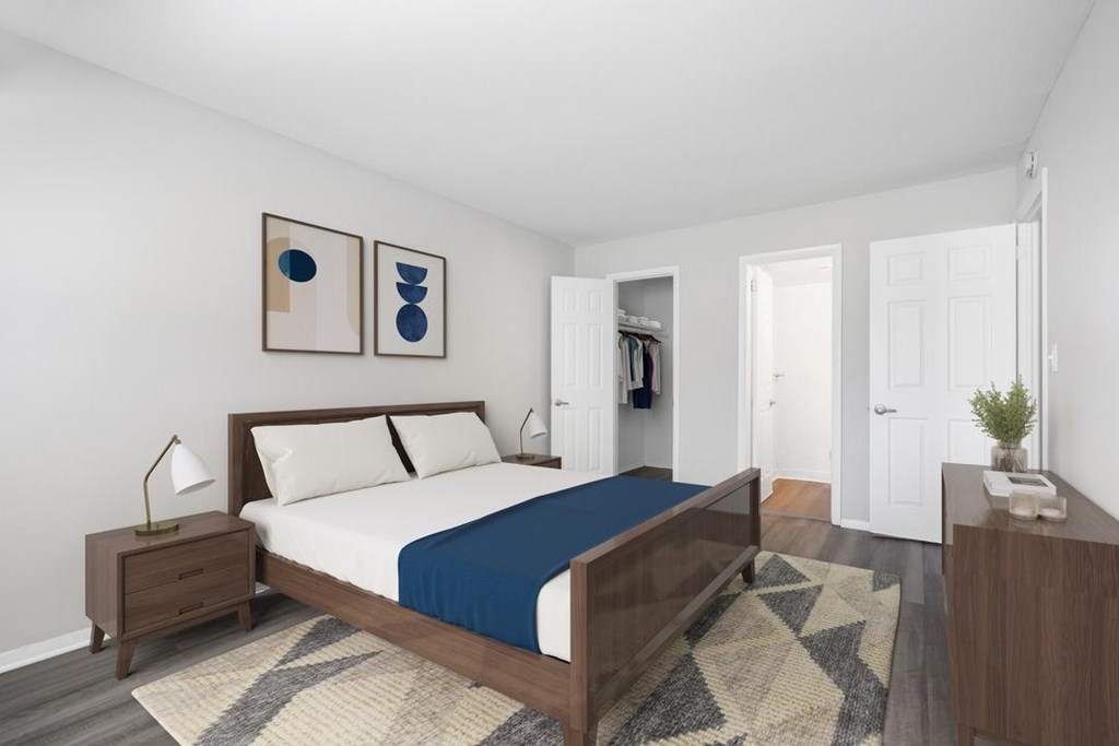 A bedroom with a bed, nightstand, and two pieces of artwork on the wall.