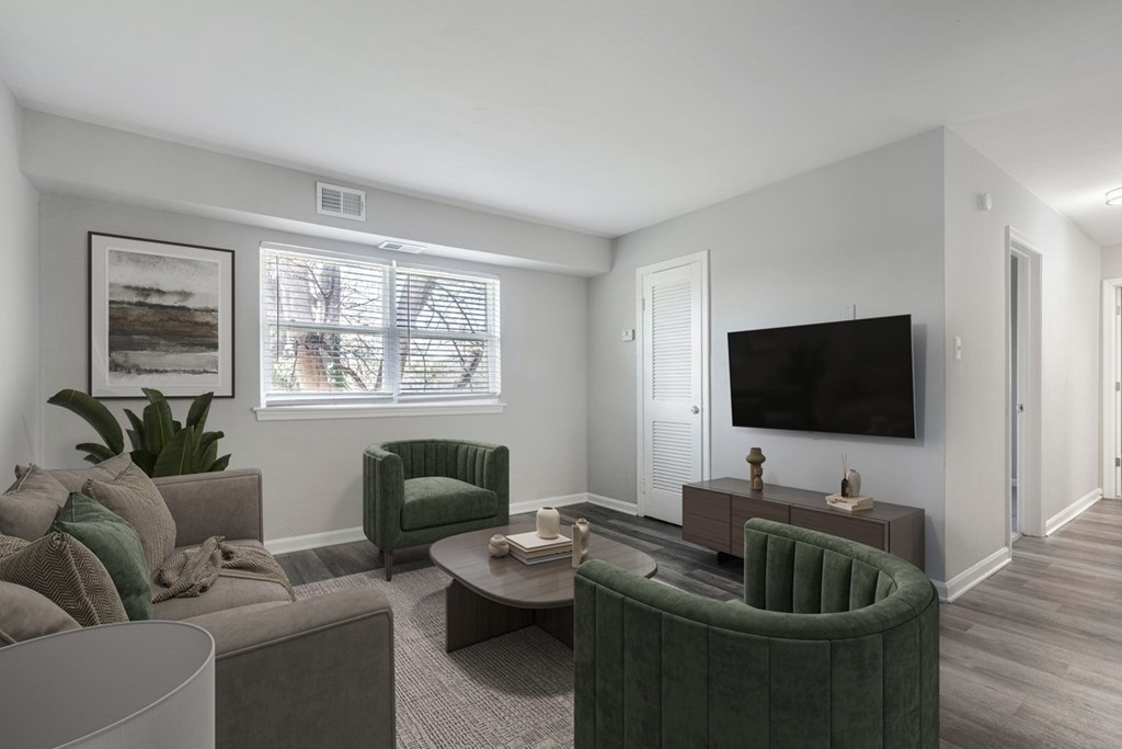 A living room with a green armchair and a grey sofa.