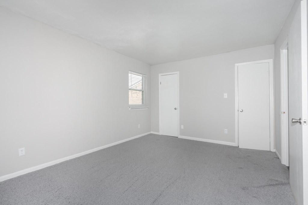 Empty room with carpeted floor and white walls.