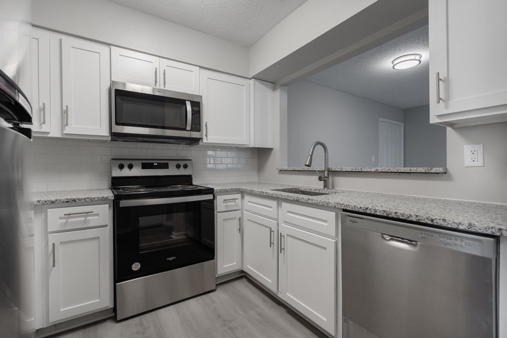 A modern kitchen with stainless steel appliances and white cabinets.