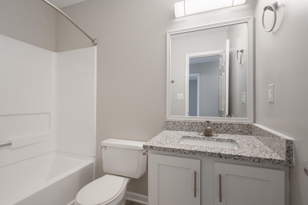 A white bathroom with a sink, toilet and bathtub.