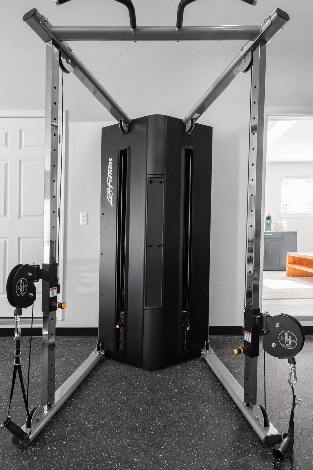 A black weight stack is attached to a squat rack.