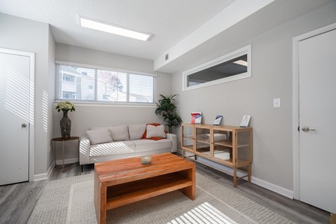 A living room with a white couch and a wooden coffee table.