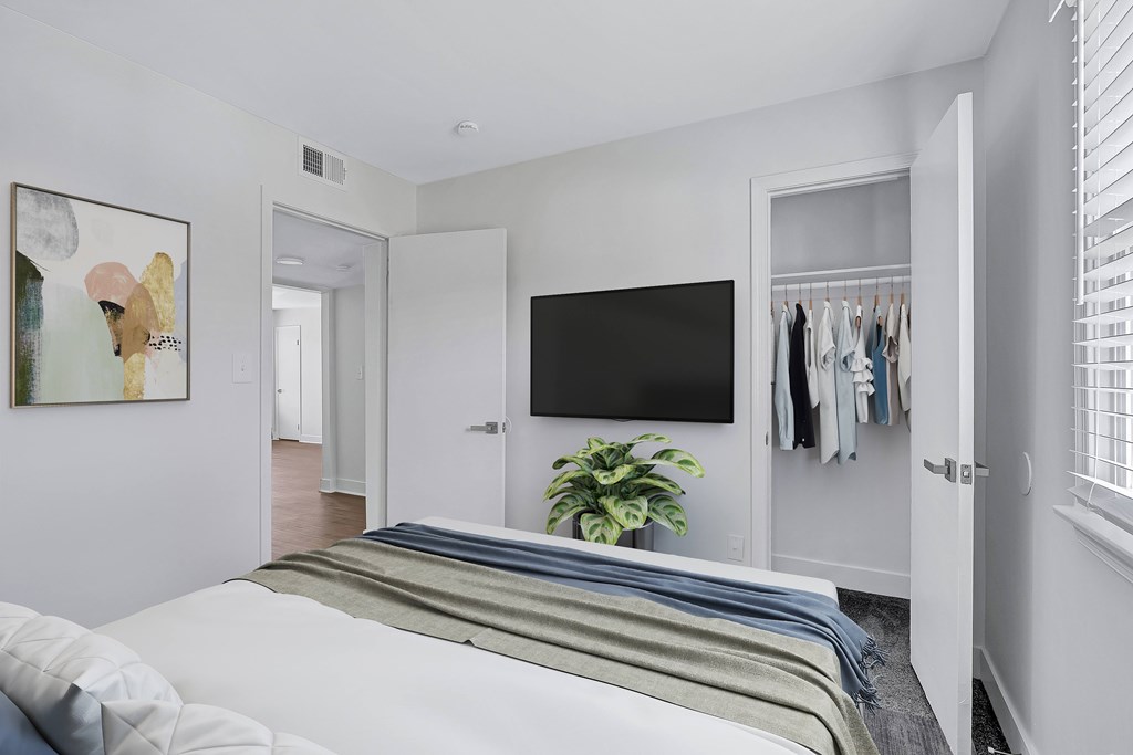 A bedroom with a bed, a TV, and a wardrobe.