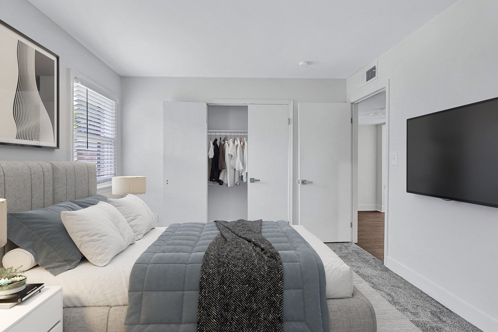 A modern bedroom with a large bed and a flat screen TV.