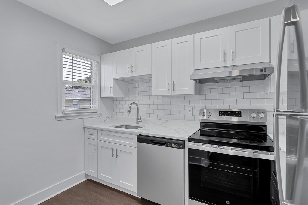 A kitchen with white cabinets and appliances.