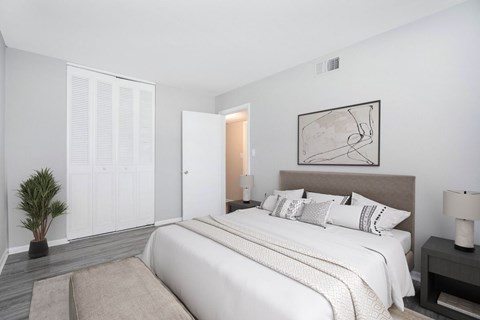 A bedroom with a large bed and a painting on the wall.