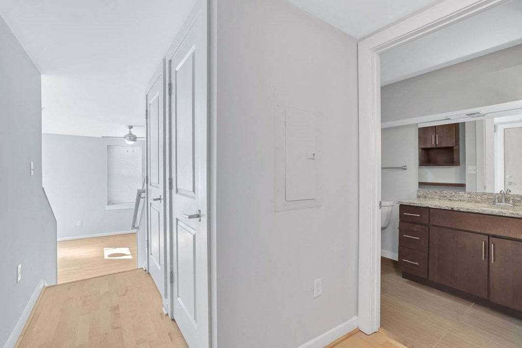 a bedroom with a door to a bathroom and a kitchen