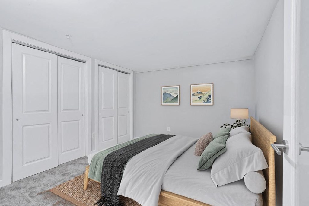 a bedroom with a bed and two closet doors