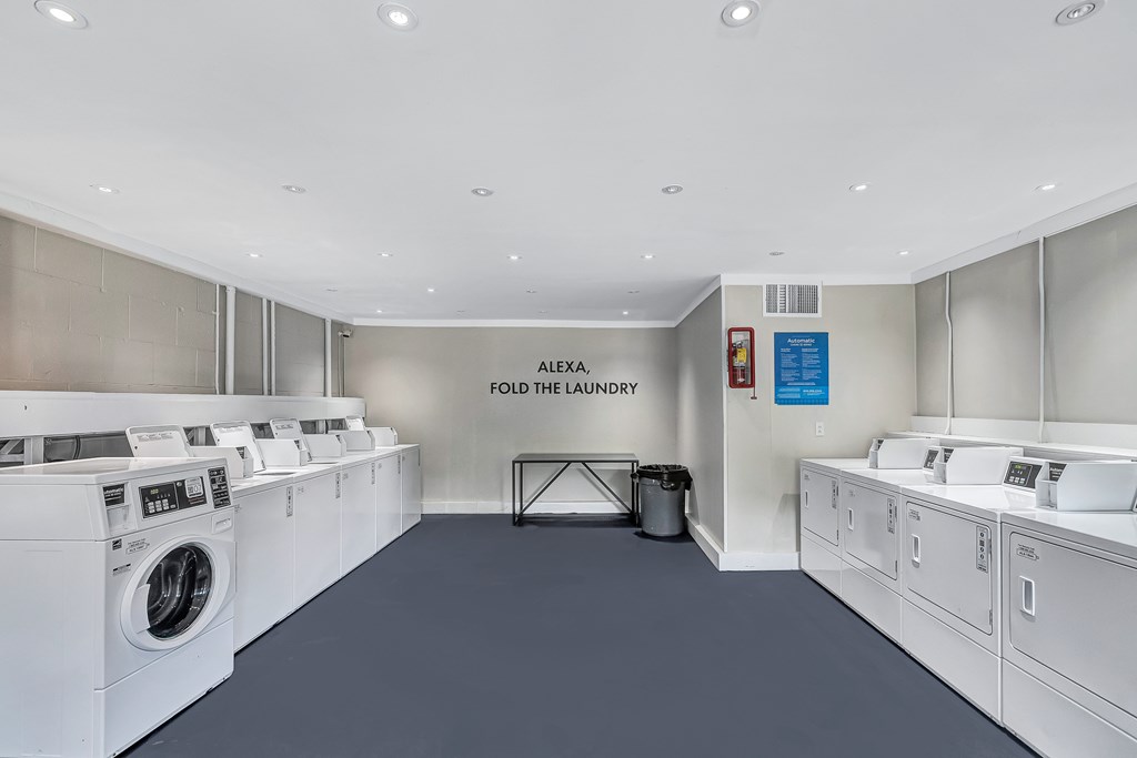 A laundromat with the sign "Alexa Fold the Laundry" on the wall.