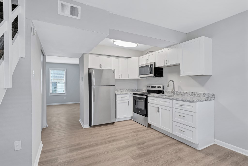 A kitchen with white cabinets and stainless steel appliances.