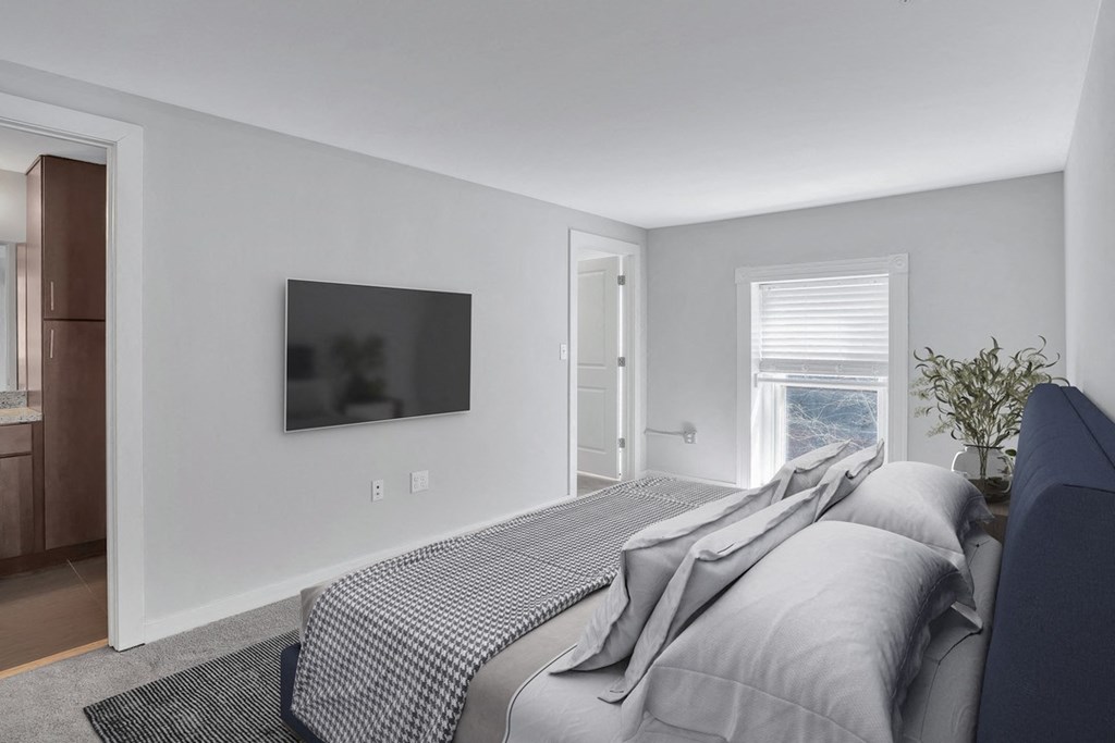 a bedroom with a bed and a tv on the wall