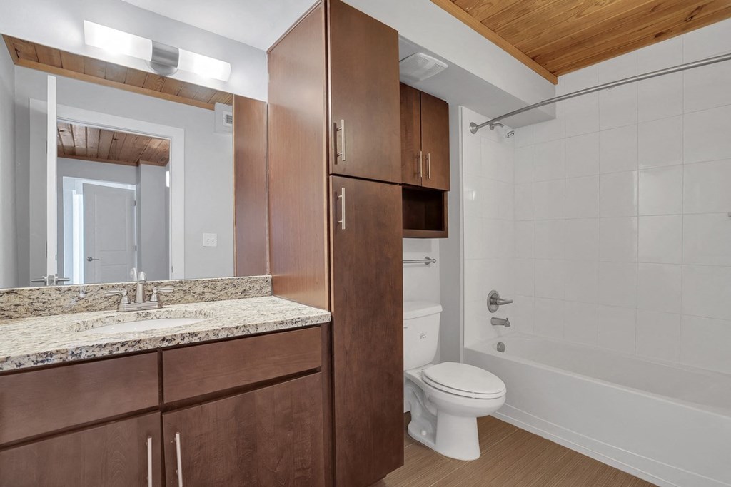 a bathroom with a toilet sink and shower and a mirror