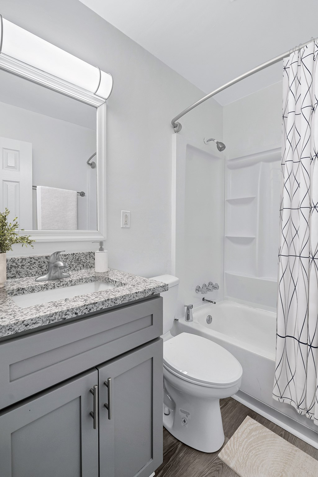 A white toilet sits in a bathroom with a grey counter top.