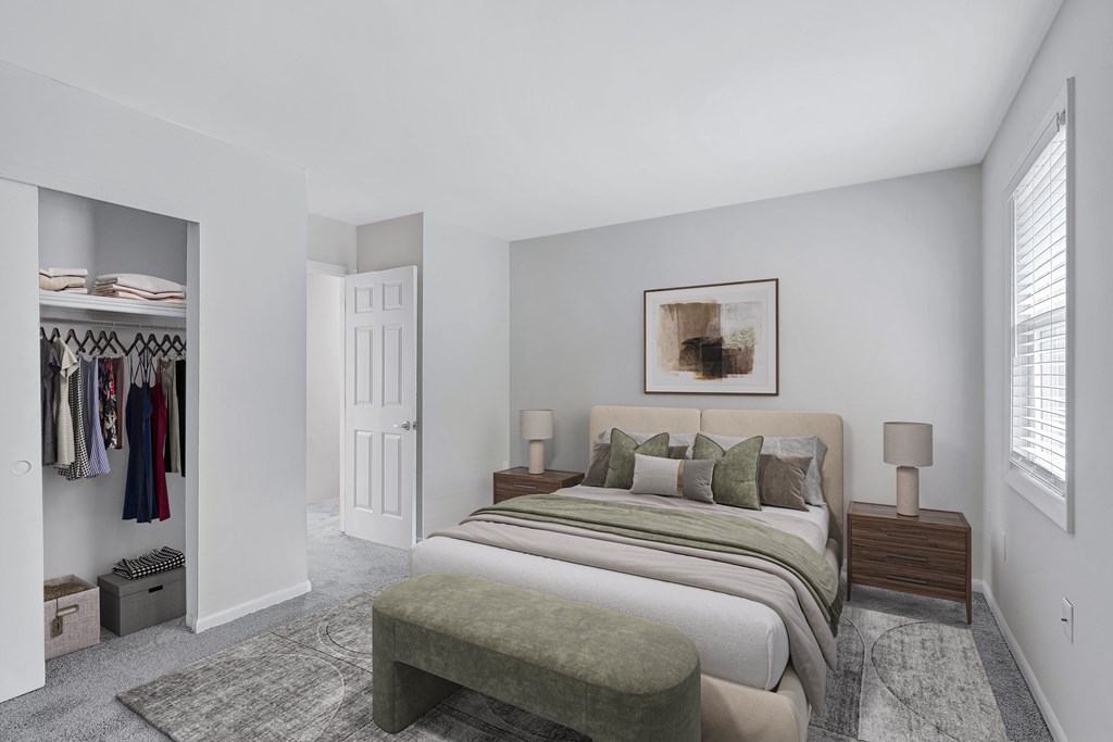 A bedroom with a large bed and a clothing closet.