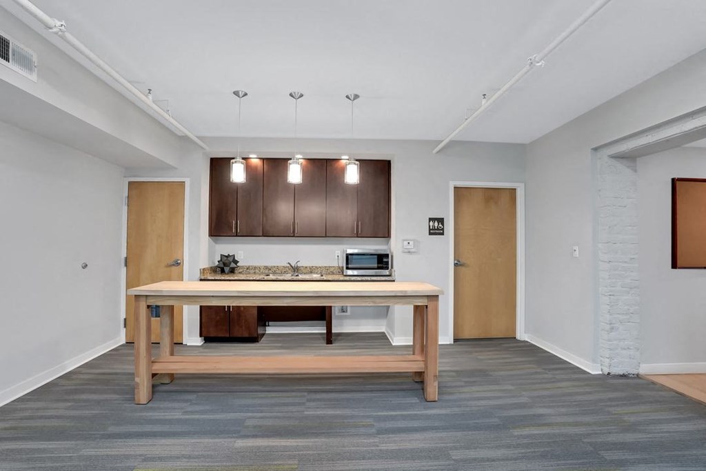 a kitchen with a wooden table in the middle of a room