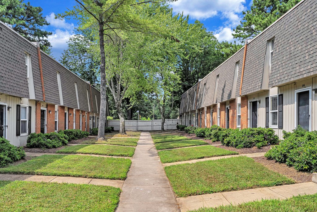 A long, narrow walkway separates two rows of identical houses.