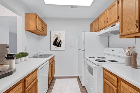 A kitchen with white appliances and wooden cabinets.