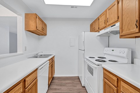 A kitchen with white appliances and wooden cabinets.